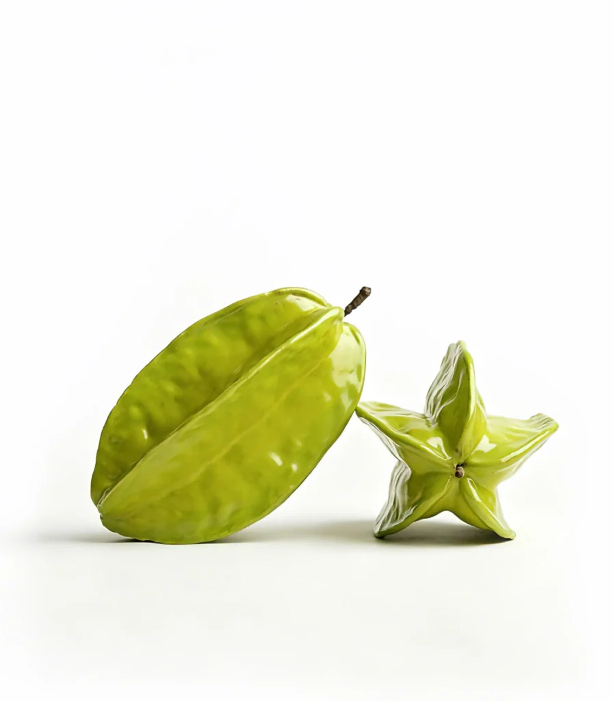 Hyper-realistic ceramic starfruit sculpture, whole and in cross-section