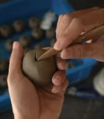 teacher gift-artisan hand-sculpting the clay body of a ceramic apple in Jingdezhen