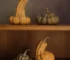 Matte handmade ceramic pumpkins in autumn tones styled on wooden shelves