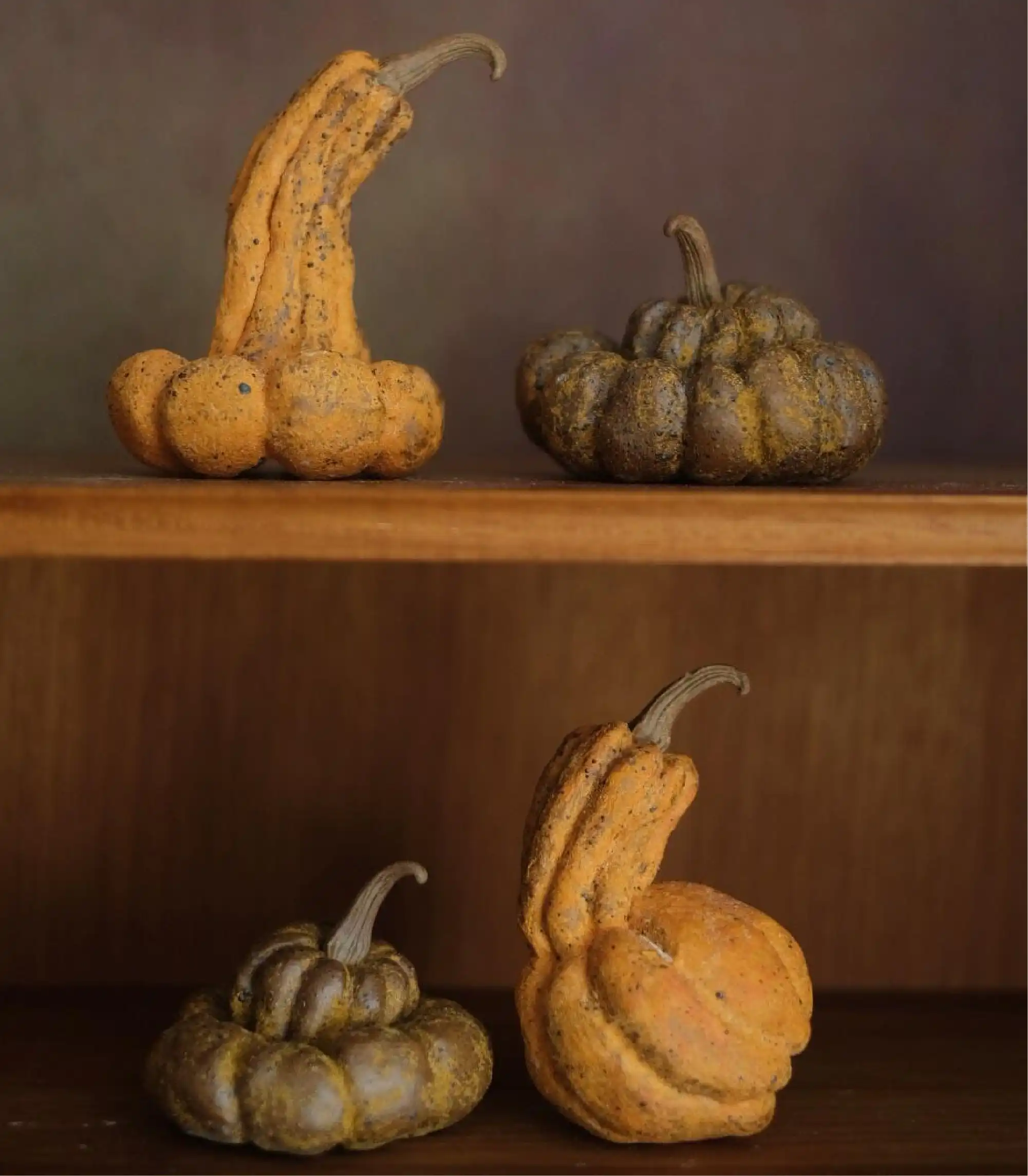 Matte handmade ceramic pumpkins in autumn tones styled on wooden shelves 01