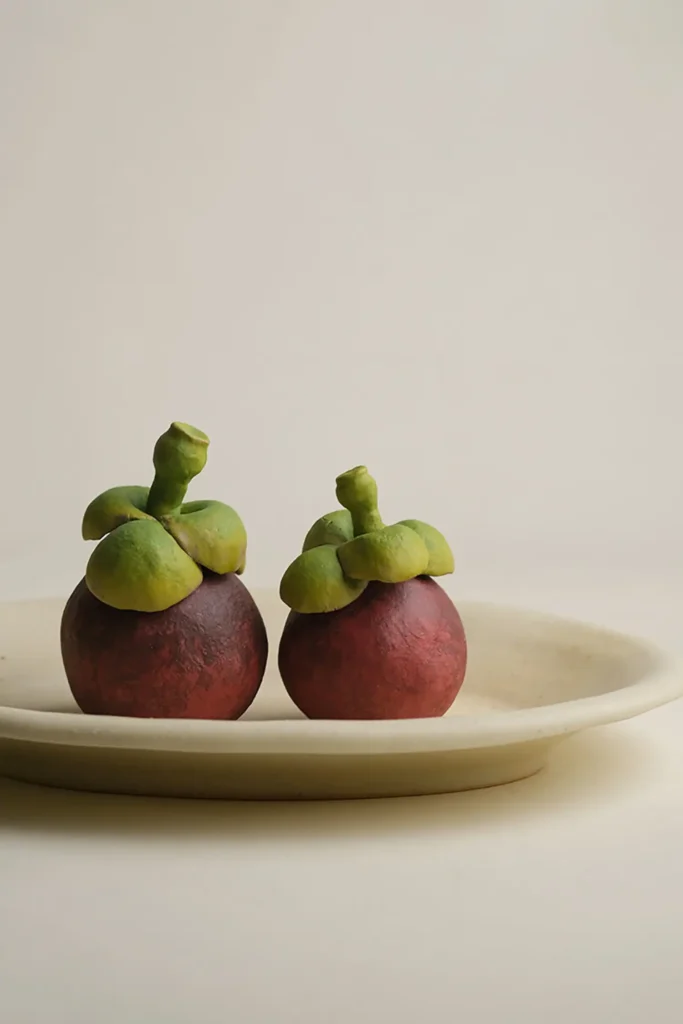 ceramic fruit decor-two ceramic mangosteen ornaments in a fruit bowl.