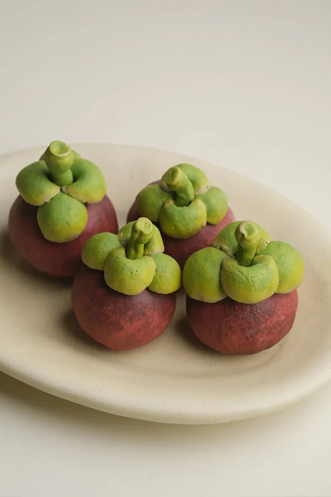 ceramic fruit decor-four ceramic mangosteen ornaments in a fruit bowl.